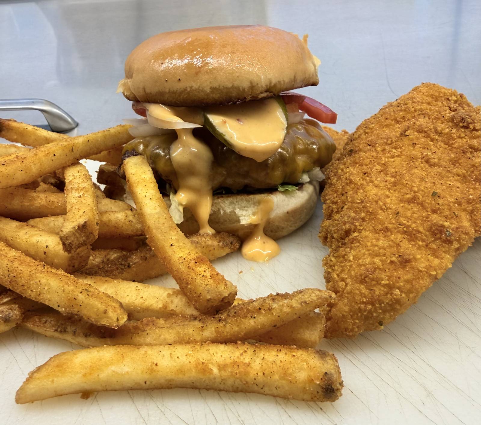 Burger with secret sauce, seasoned fries and a crispy chicken tender